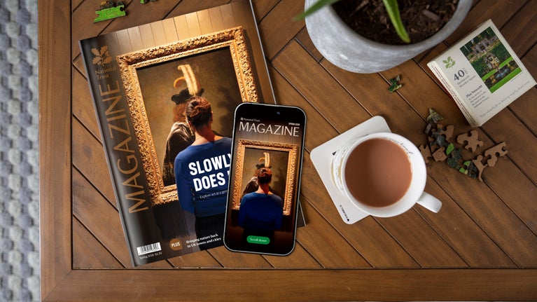 National Trust's Spring 2026 magazine on a coffee table with a mobile phone